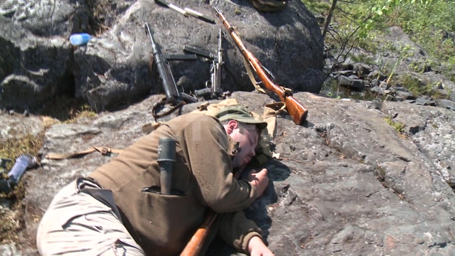"А зори здесь тихие..." - съемки фильма в Карелии, статист в военной форме ВОВ спит на камне, рядом