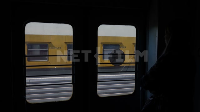 Электричка, тамбур, вид из окна, в кадре станция, дома. Двери открываются, люди выходят из