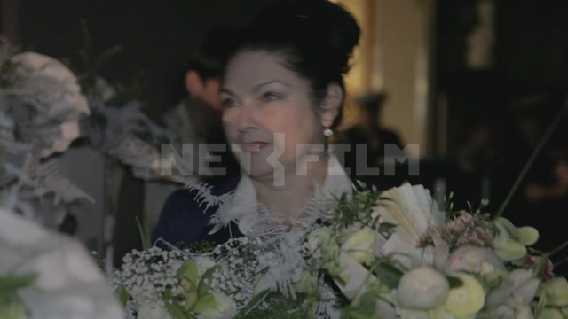 За кулисами после спектакля (концерта), в кадре люди с цветами