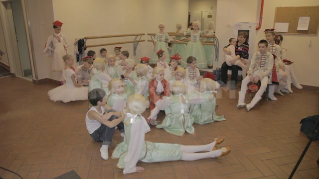 Children (students of the ballet school) in stage costumes and wigs before the start of the