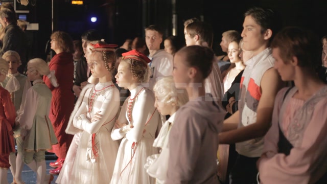 Ballet dancers, students of the ballet school, stand behind the scenes, looking at the stage