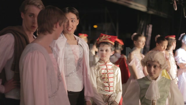 Ballet dancers and children (students of the ballet school) in stage costumes backstage, before the