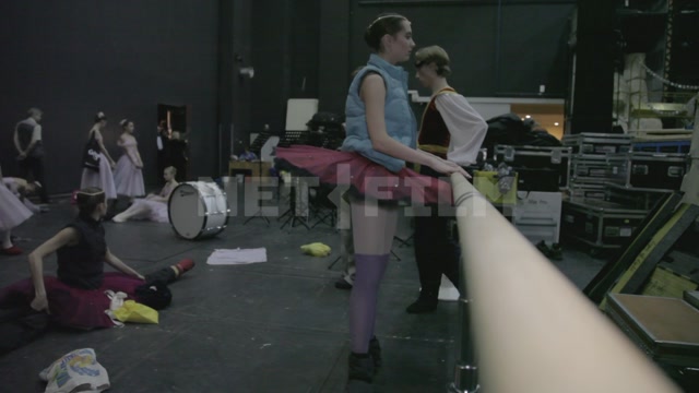 Ballet dancers backstage, before the start of the performance - rehearsing, warming up, resting