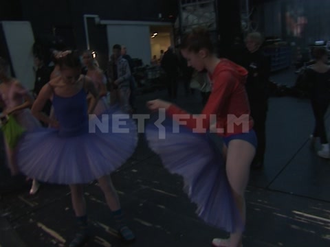 Ballet dancers backstage, putting on their tutus, preparing for a performance