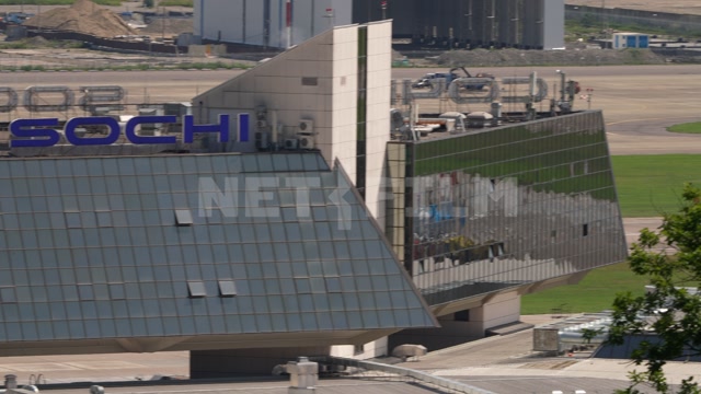 Международный аэропорт города Сочи, лето, день. В кадре здания аэропорта, взлетная полоса. Самолет