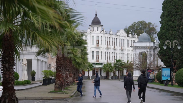 Абхазия, Сухуми, осень, день. Здание отеля "Рица". Пальмы, променад, гуляют люди