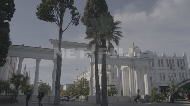 Абхазия, Сухум, центр города. Пальмы, белая арка, здание гостиницы "Рица", набережная, гуляют люди