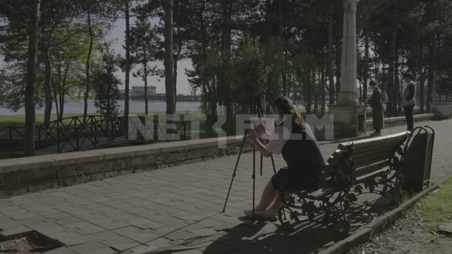 Abkhazia, Sukhum, embankment, park. A girl with an easel painting