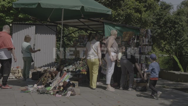 Abkhazia, Sukhum, summer, daytime. Souvenir stalls, vacationers in the frame