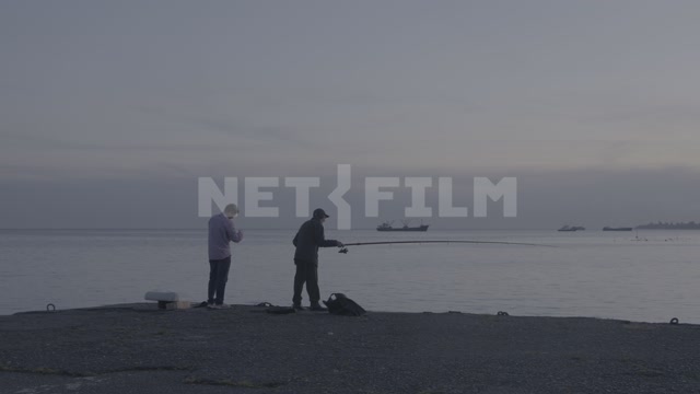 Abkhazia, Sukhumi, evening, sunset. Embankment, sea, fishermen with fishing rods