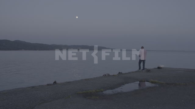 Abkhazia, Sukhumi, evening. Embankment, sea, man with a fishing rod in the frame